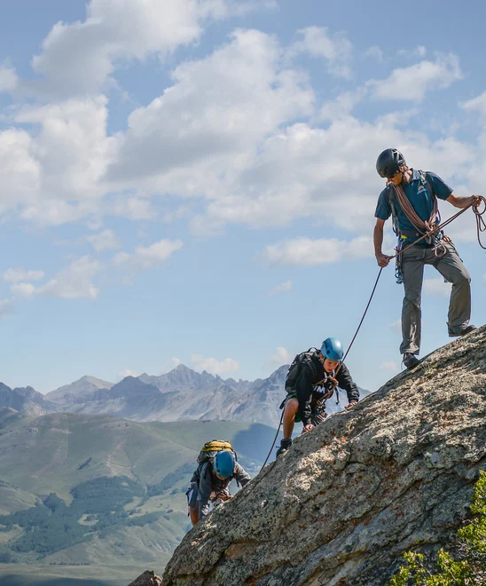 A group of climbers going up a ridge with a guide in the Rockies.