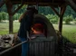 Chef putting food into a wood-fired oven.