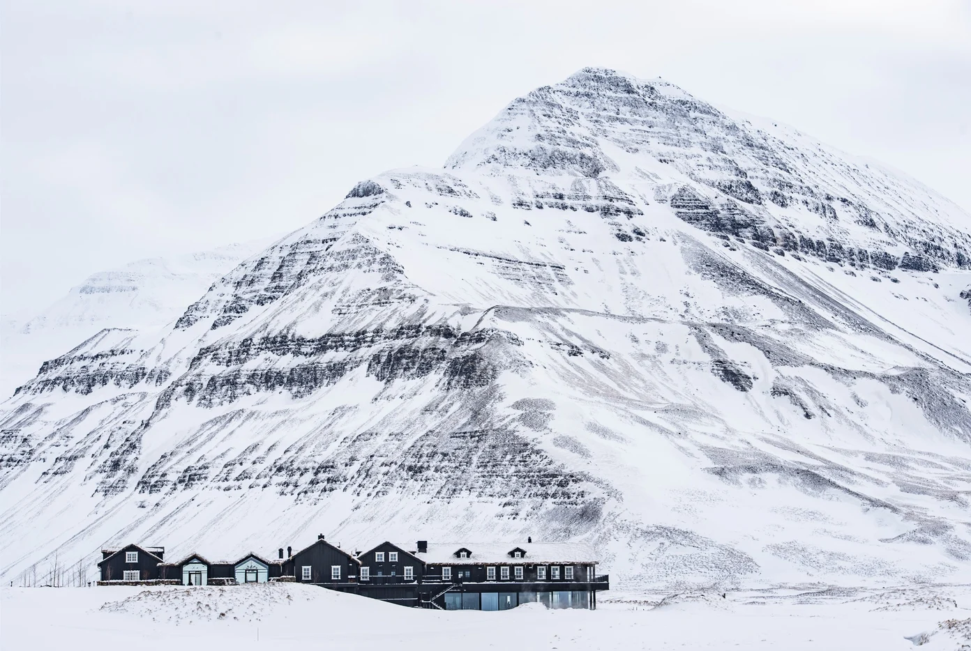 Deplar Farm covered in snow with a mountain behind it.