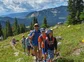 A happy guide and a couple families walking a mountain trail in Colorado