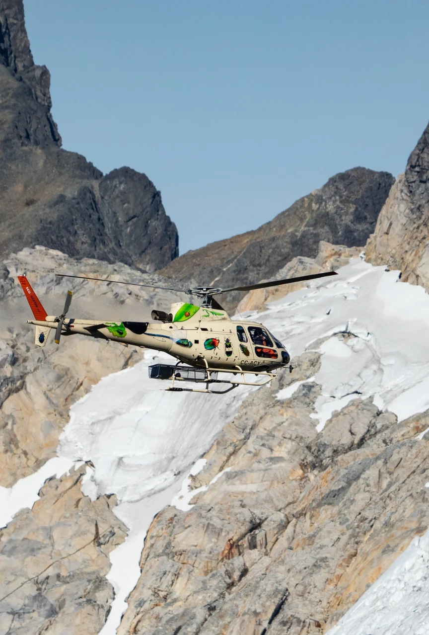Helicopter flying through Patagonian mountains.