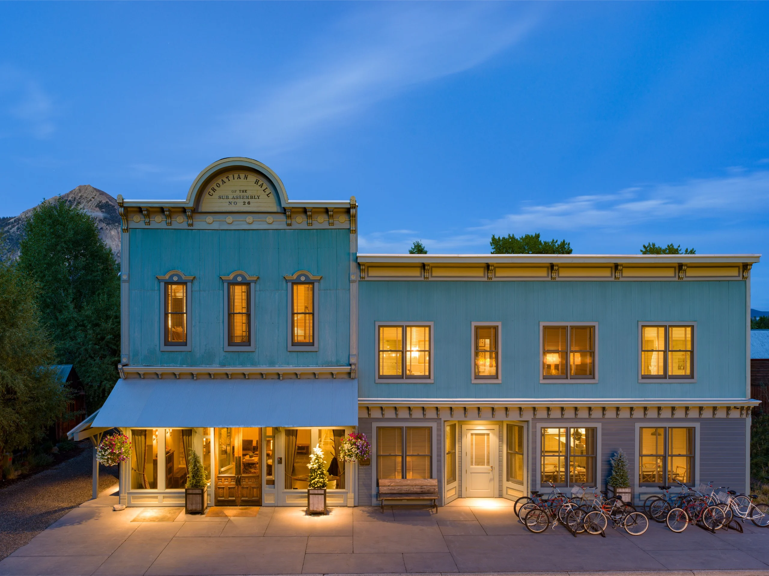 A full view of Scarp Ridge Lodge with bikes parked out front at dusk.