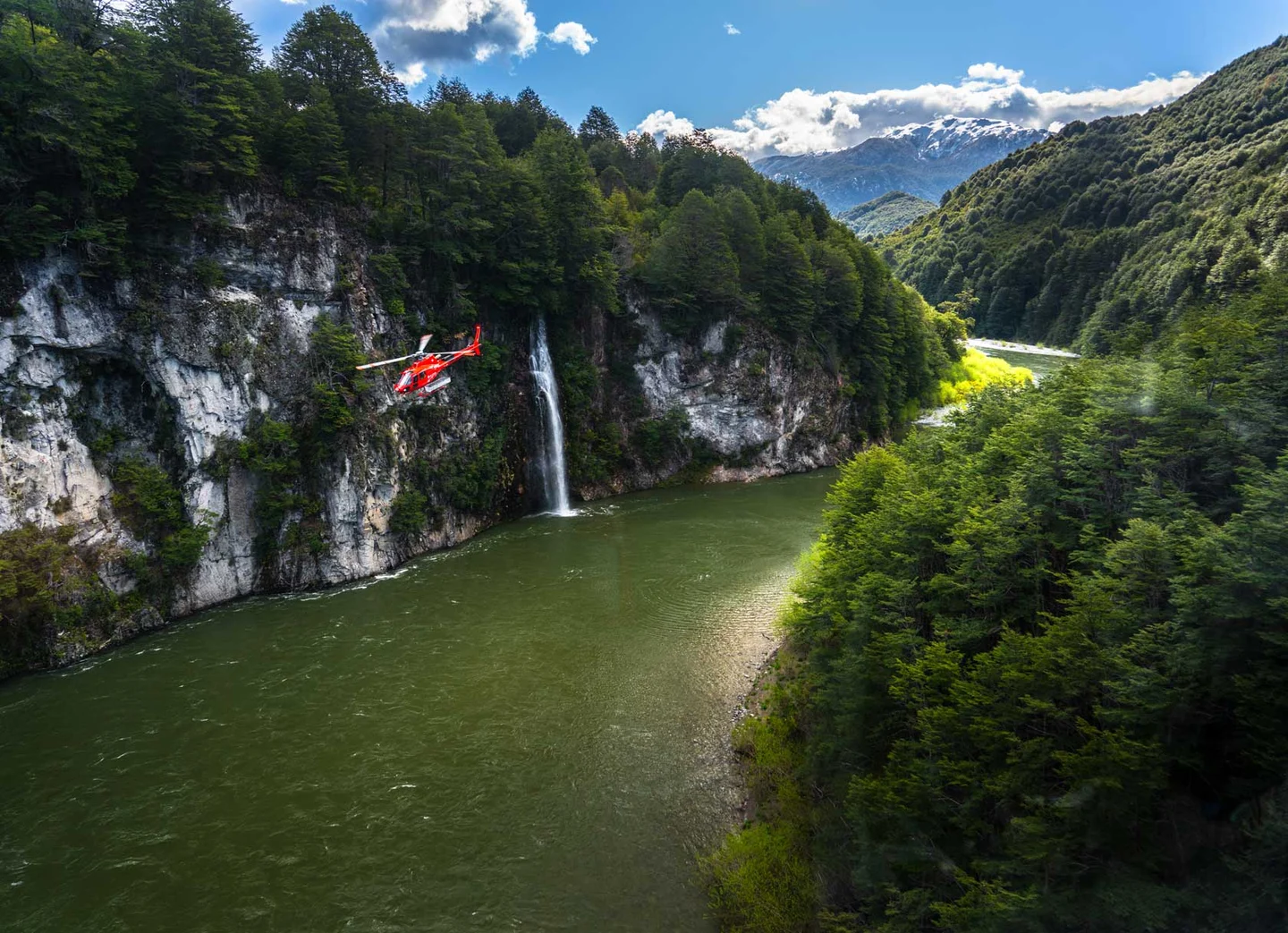 A helicopter flies over a Patagonian river.