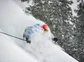 Male skier surrounded by powder snow while skiing.